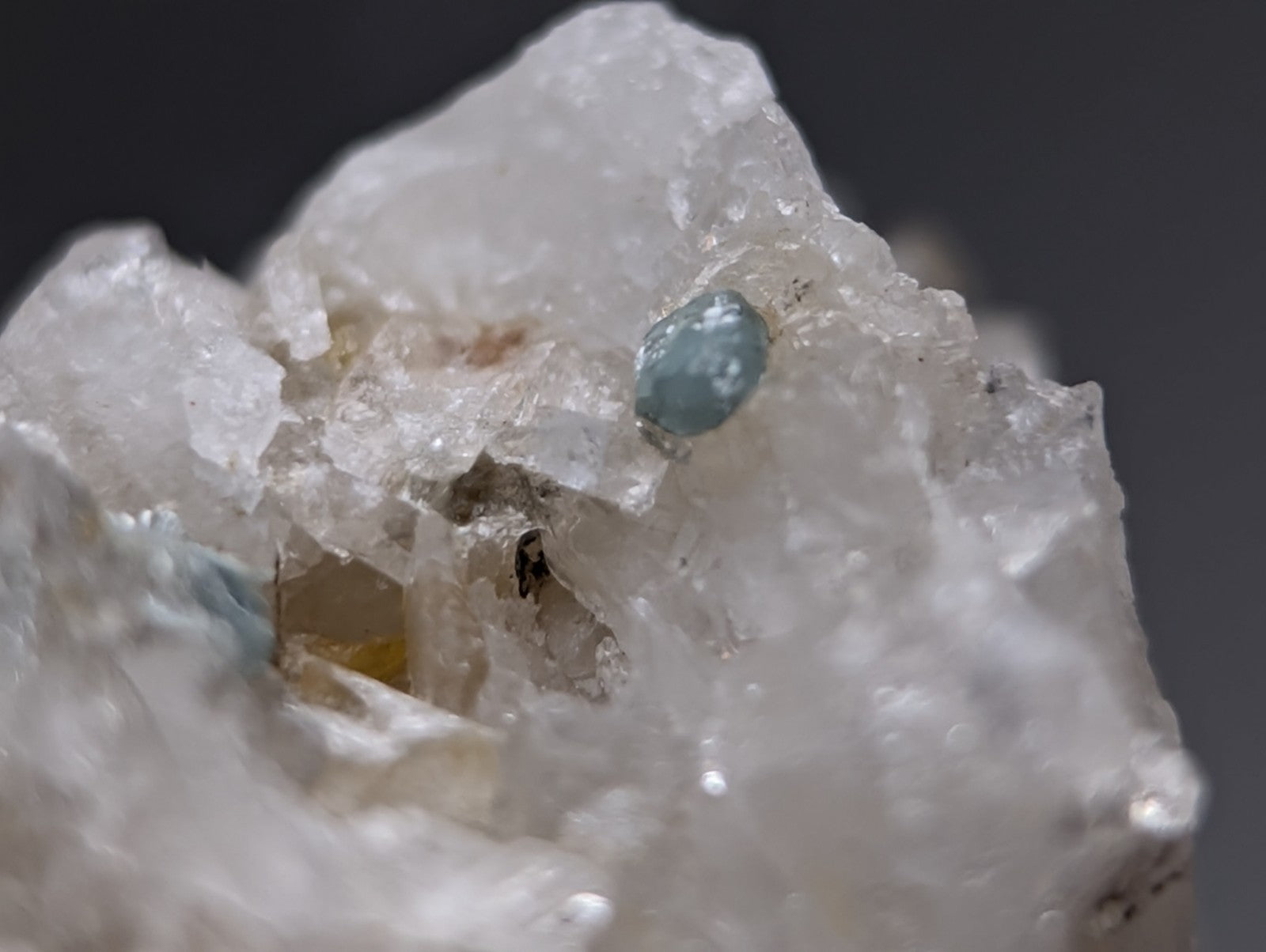A translucent light blue blue-green cookeite gemstone nestled on clear crystalline quartz from saline county arkansas