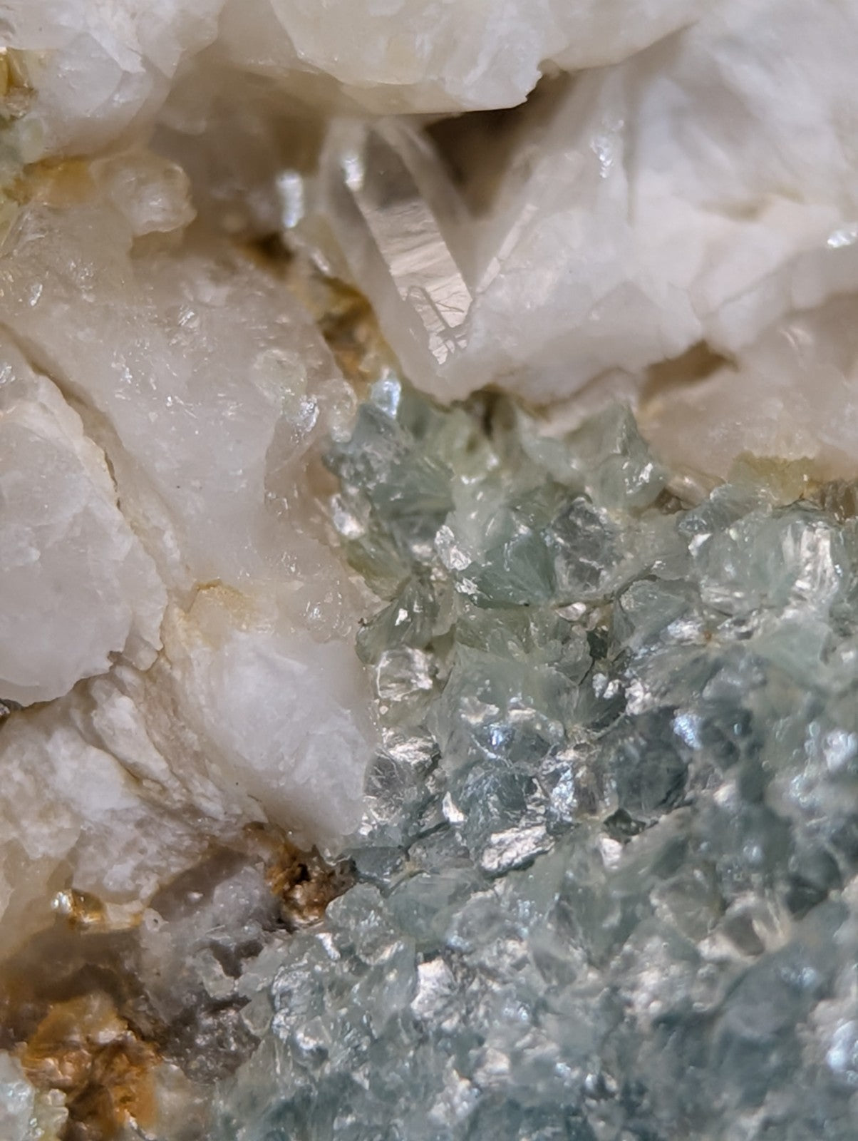 A cluster of translucent white and pale green quartz crystals in blue green cookeite on quartz from saline county arkansas