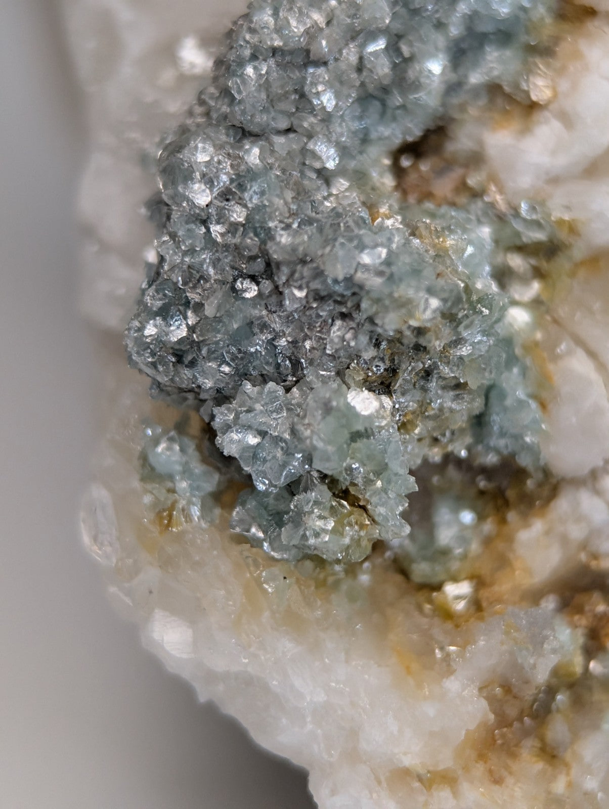 A cluster of translucent blue green cookeite crystals with faceted texture on quartz from saline county Arkansas rare UV reactive