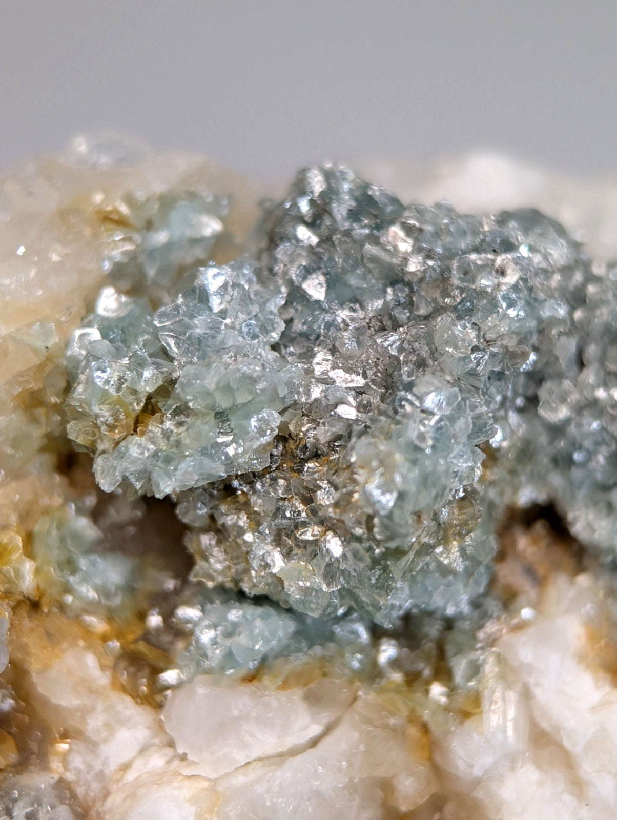 A cluster of translucent light blue blue green cookeite crystals on quartz from saline county Arkansas rare UV reactive mineral