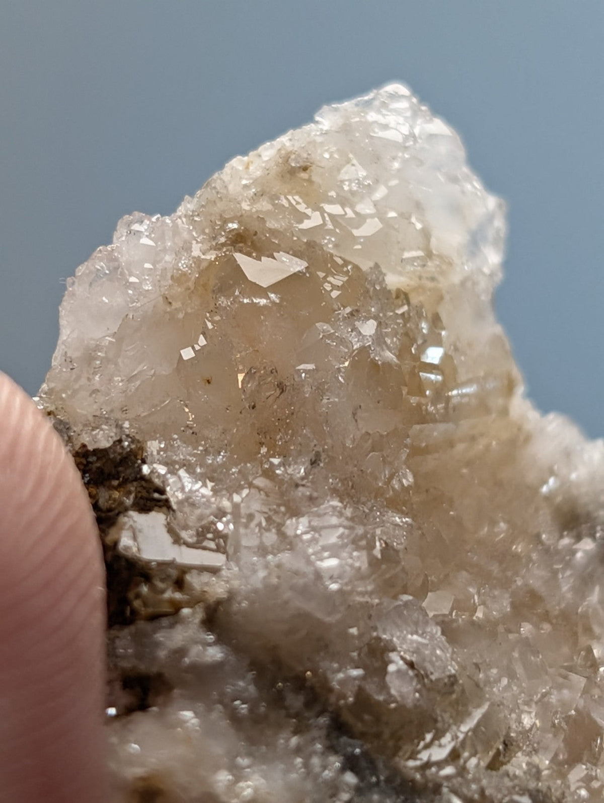 A translucent blue green cookeite on quartz with a rough surface and golden brown inclusions from Arkansas