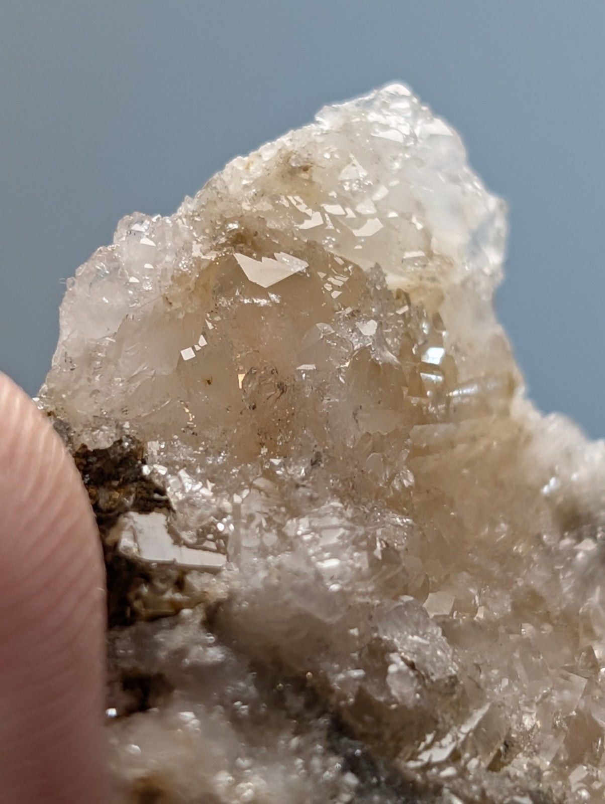 A translucent blue green cookeite on quartz with a rough surface and golden brown inclusions from Arkansas