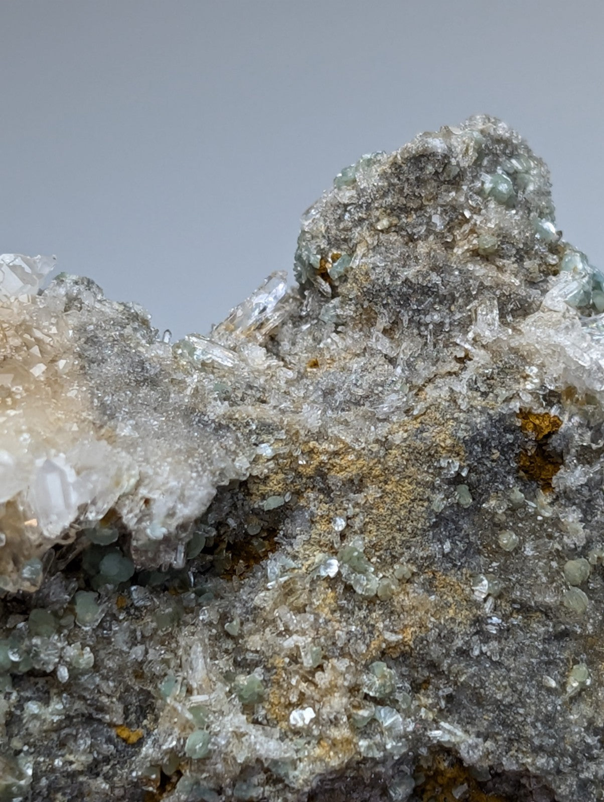 Rugged blue green cookeite on quartz specimen with translucent green crystals and yellow orange patches from arkansas