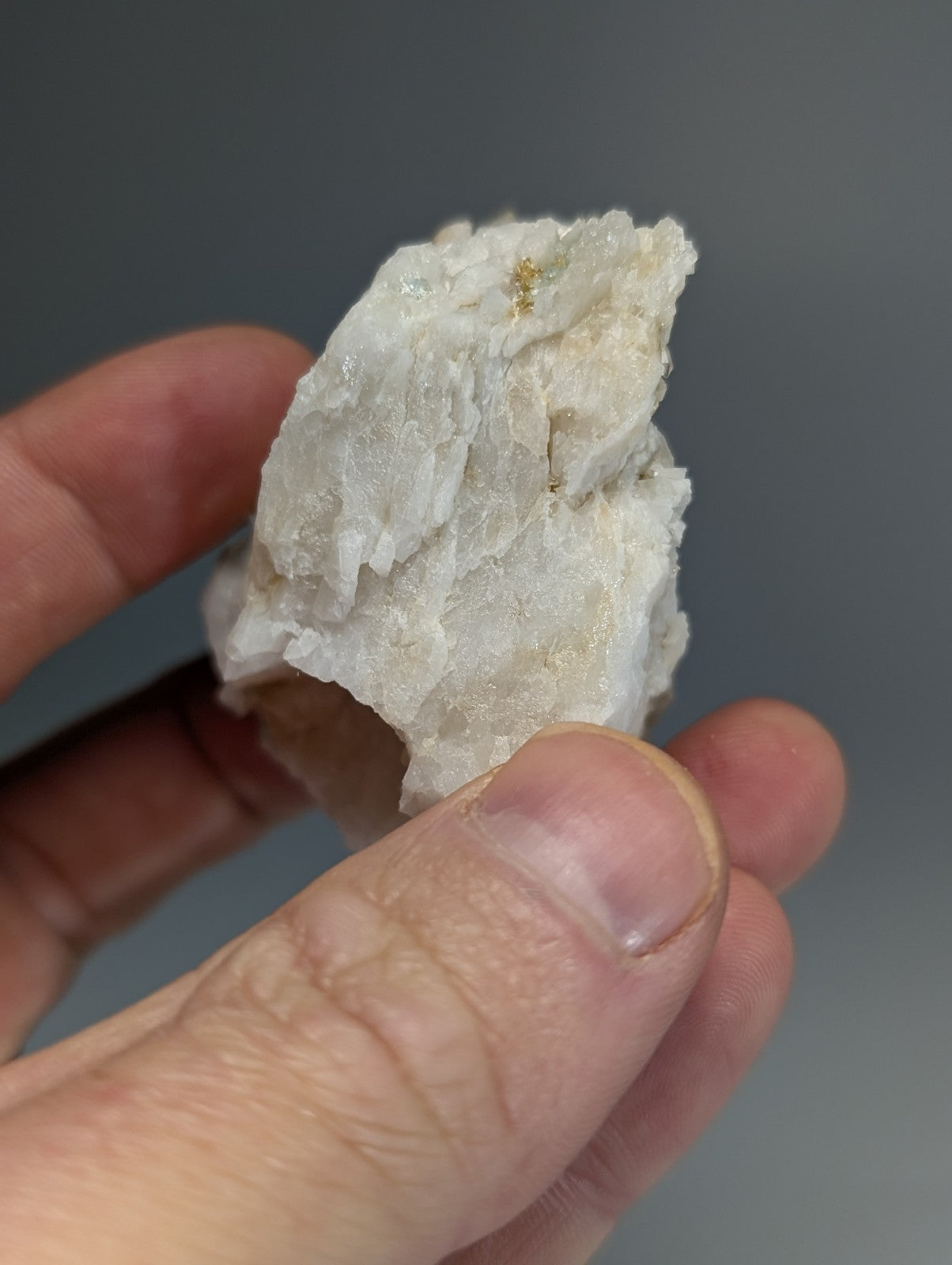 A white crystalline blue green cookeite on quartz mineral with golden inclusions and rough jagged surface from arkansas