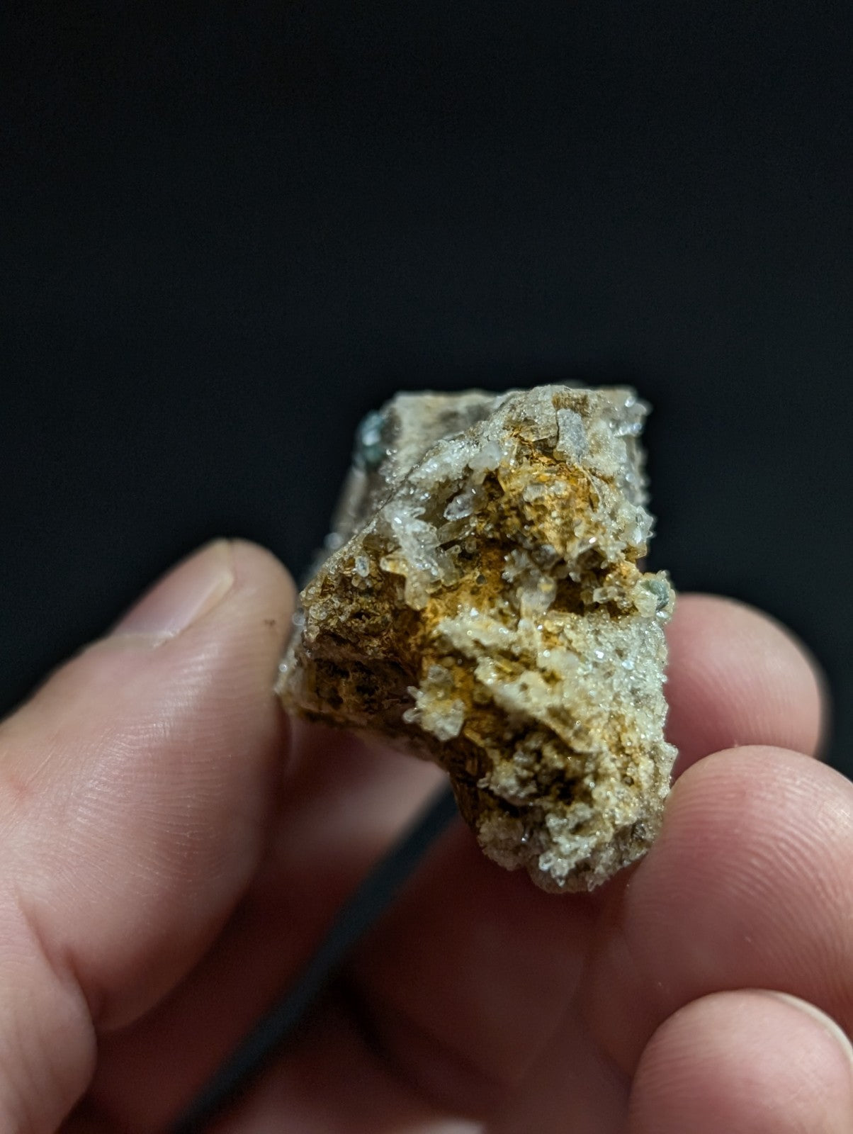 A rough, irregularly shaped mineral specimen with a mix of translucent white and earthy yellowish-brown patches.