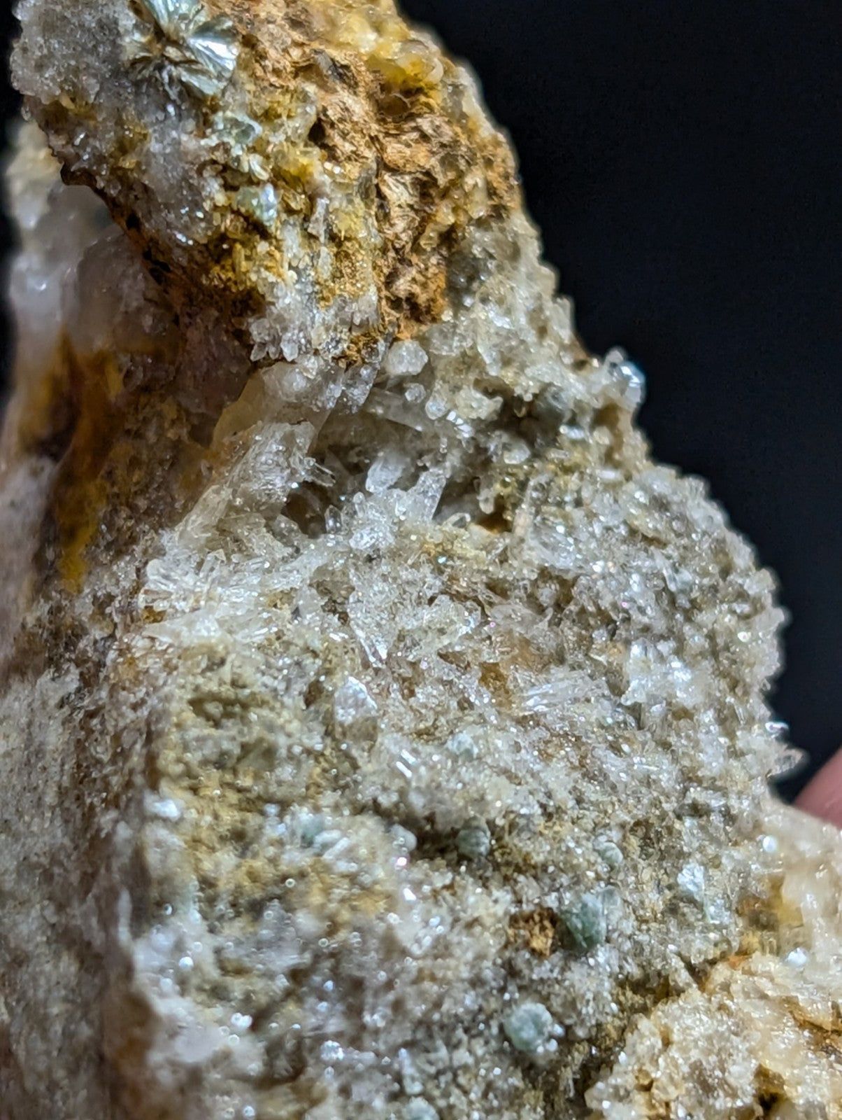 A rugged, translucent quartz crystal formation with golden and grayish hues, embedded in a rough matrix of earthy minerals.