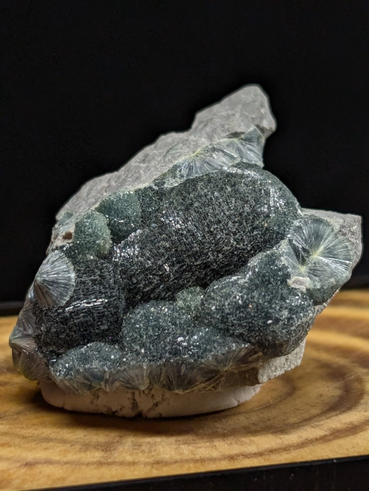 A striking green and translucent mineral specimen with intricate, fan-like crystal formations.