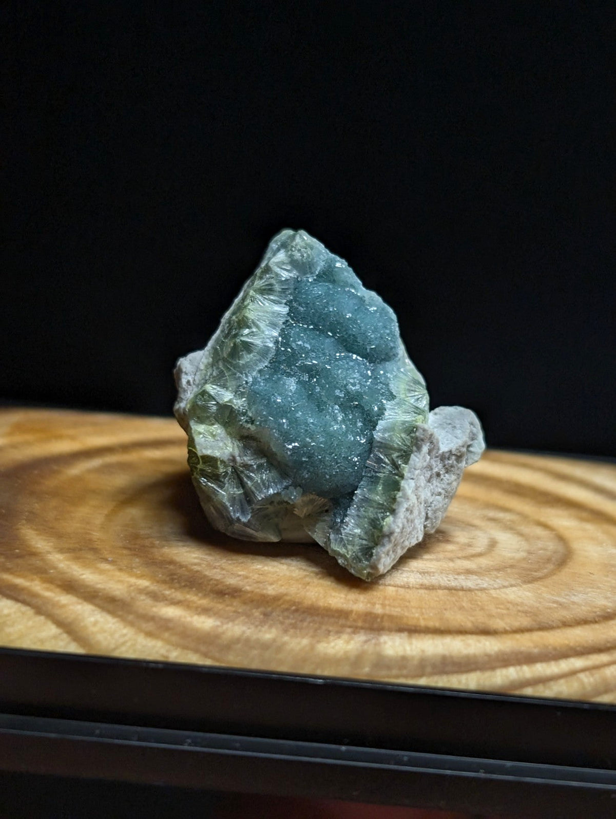 A striking teal-green mineral specimen with a crystalline, textured surface and natural rock matrix.
