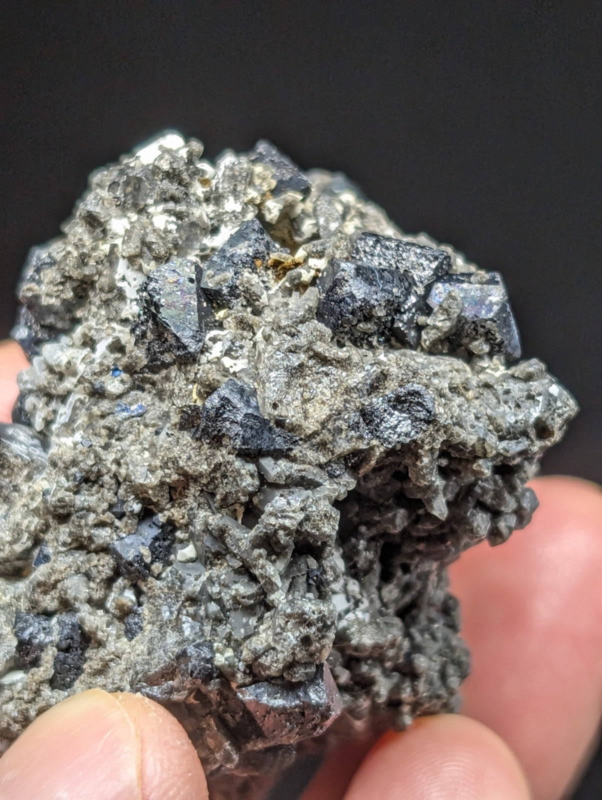 A rugged, dark gray mineral specimen with sharp, crystalline facets and metallic sheen.