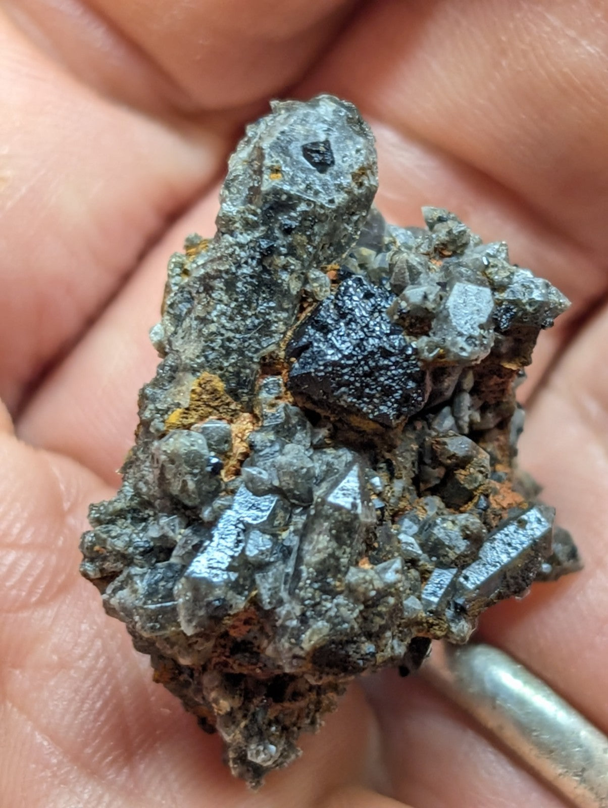 A rugged, grayish-black mineral specimen with metallic sheen and crystalline facets.