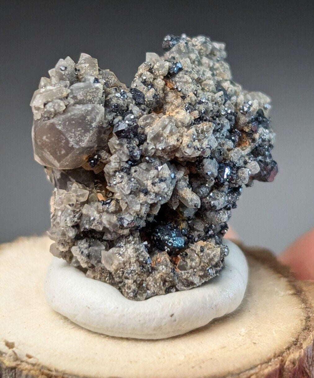 A striking gray and black mineral specimen with crystalline formations, featuring a mix of translucent quartz-like crystals interspersed with darker metallic-looking inclusions.