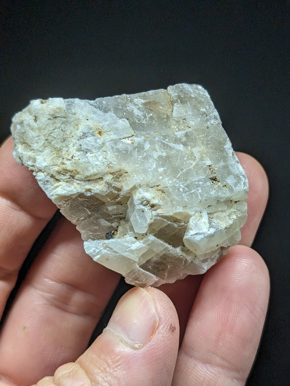 A translucent, pale greenish-white mineral specimen with a crystalline structure and visible internal fractures.