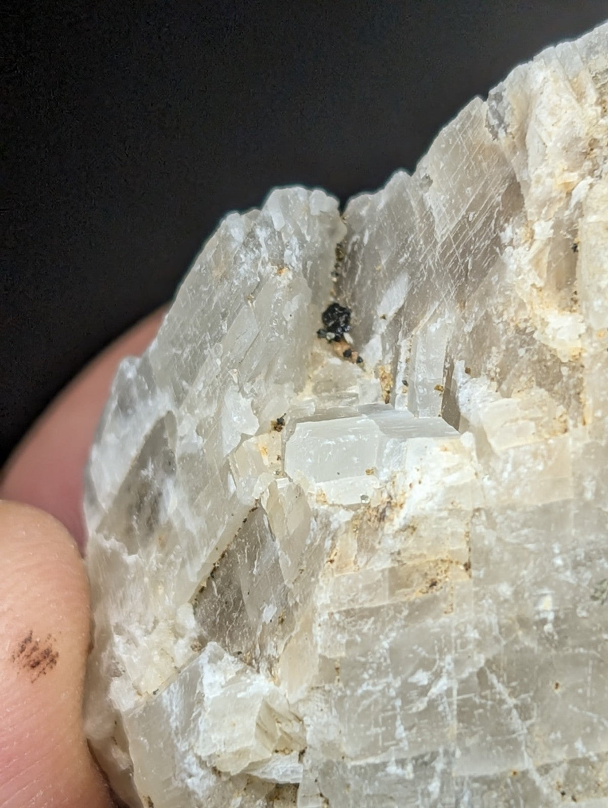 A translucent, crystalline mineral specimen with sharp, angular facets and a predominantly clear to pale white hue.