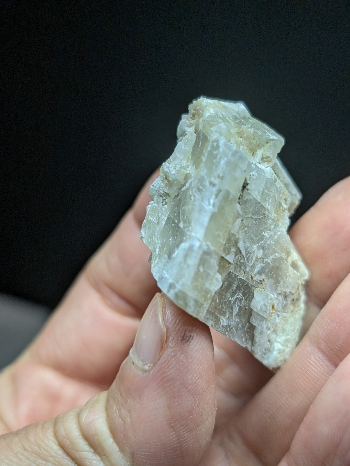 A translucent, pale green mineral specimen with a crystalline structure and jagged edges.
