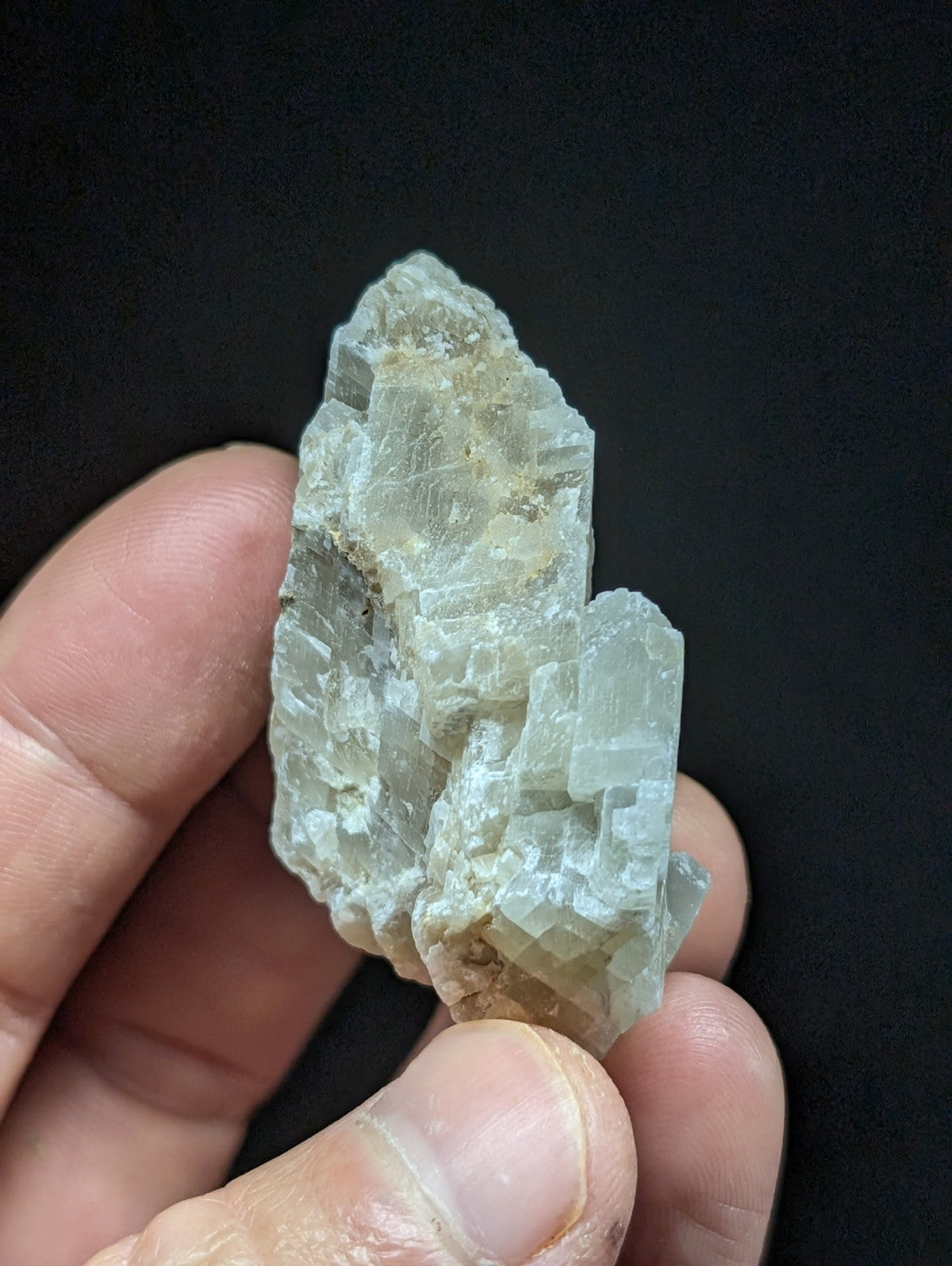 A translucent, pale green mineral specimen with a crystalline structure and visible facets.