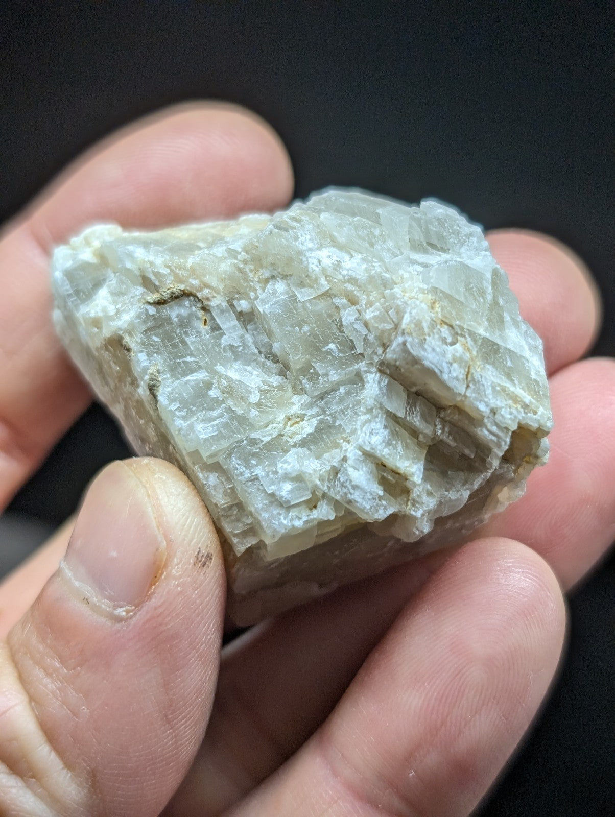 A translucent, pale greenish-white mineral specimen with a crystalline texture and jagged edges.