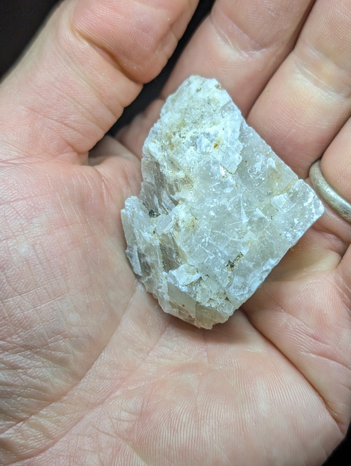 A translucent, pale white mineral specimen with crystalline facets and subtle yellowish inclusions.