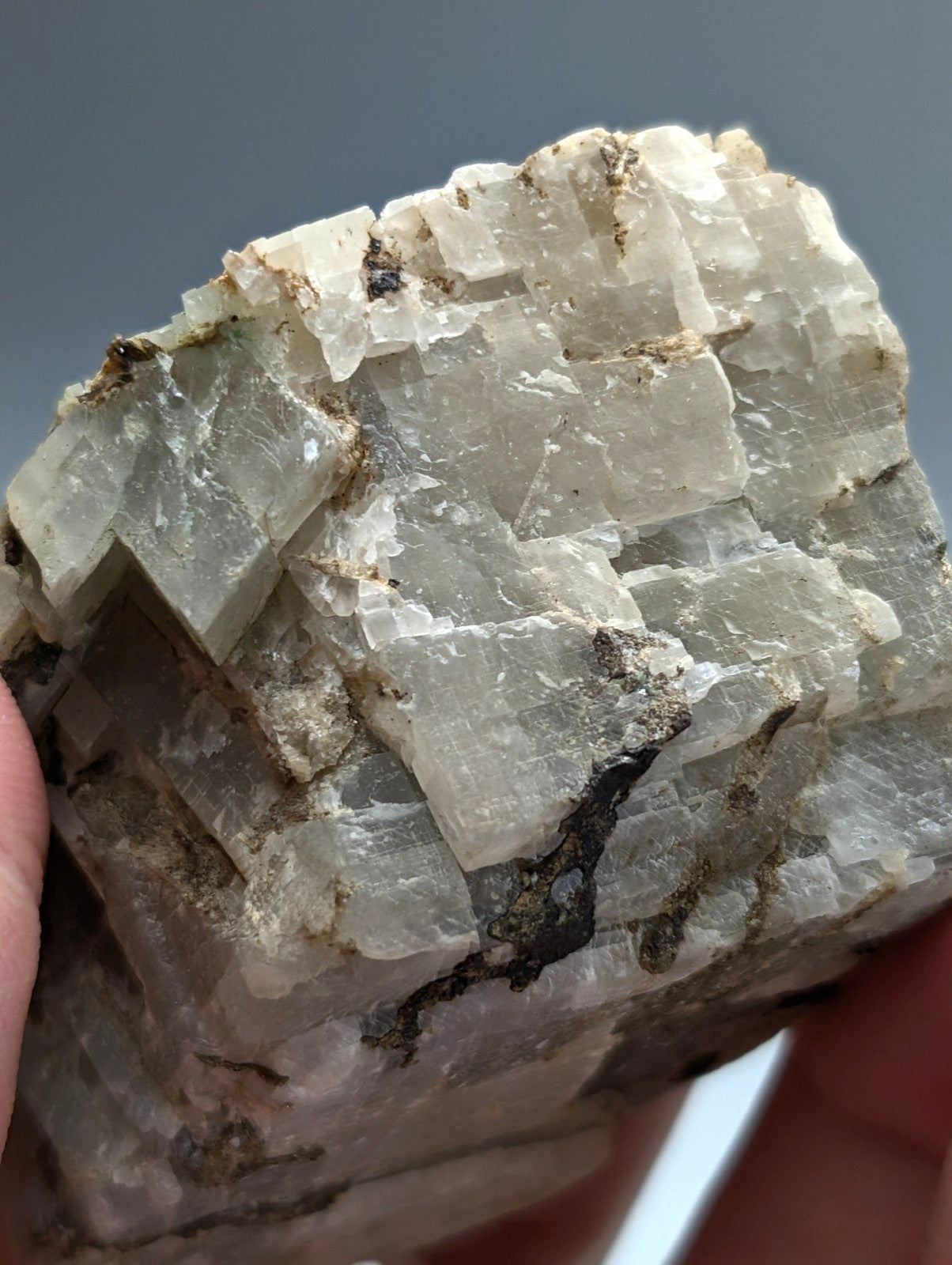 A translucent calcio carbonatite mineral specimen with layered geometric structure and subtle earthy discolorations from Arkansas