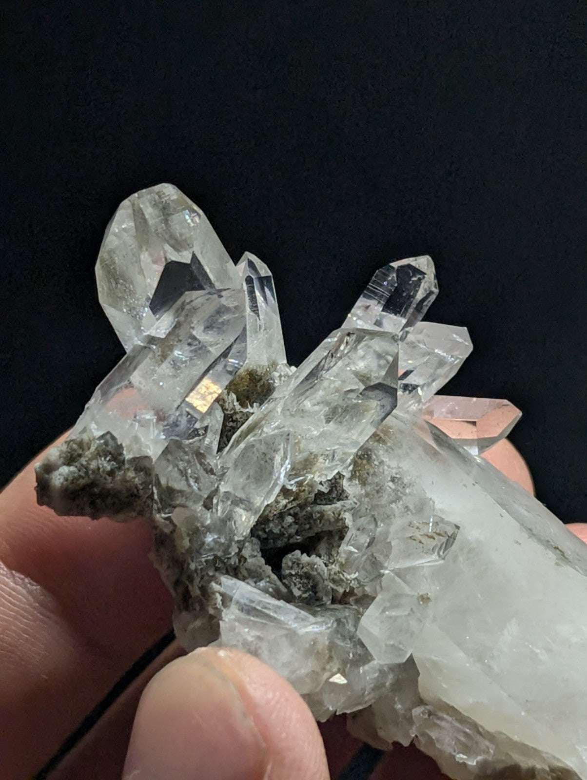 A clear quartz crystal cluster with sharp, faceted points and a translucent quality.