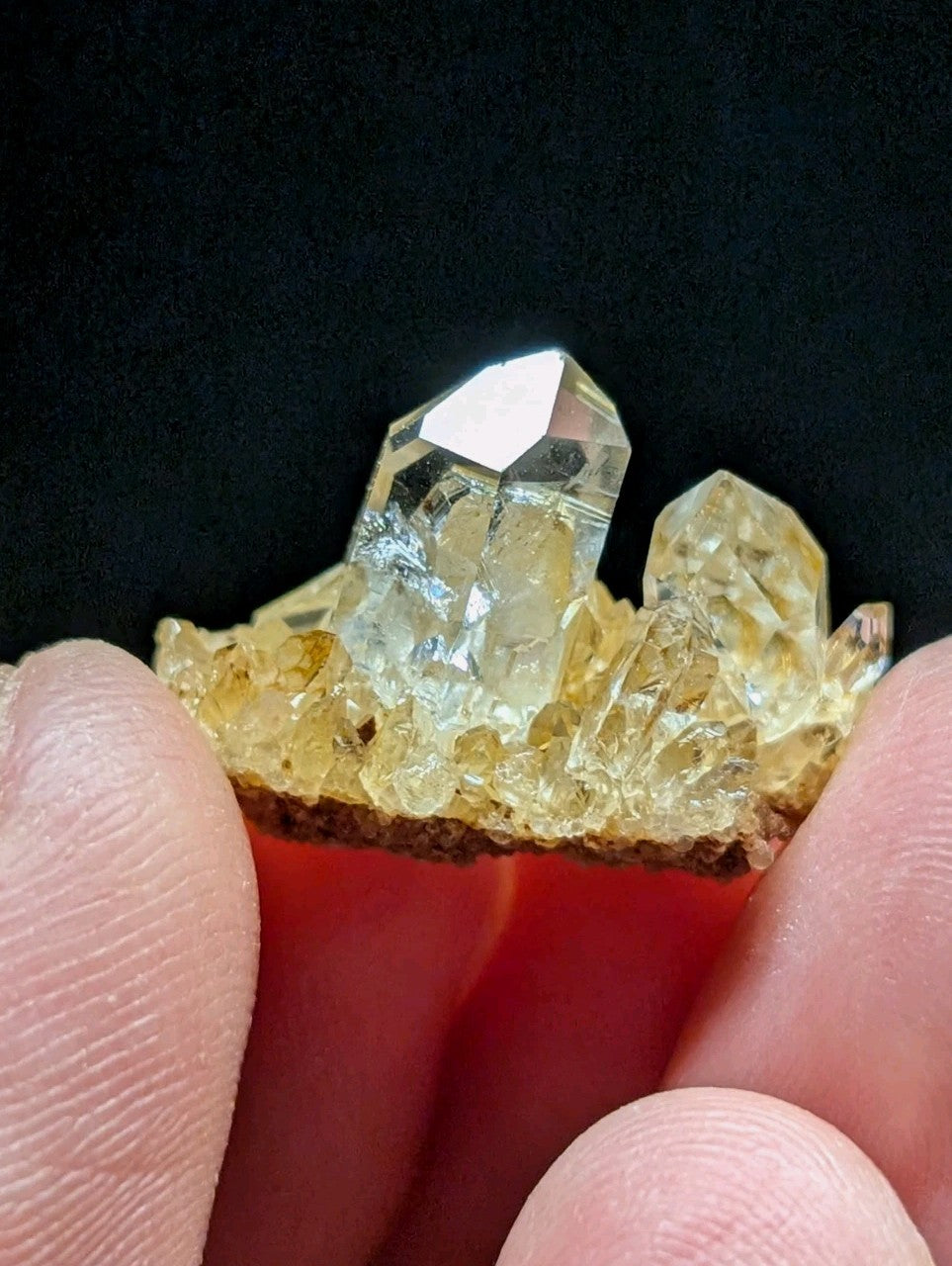 A translucent yellow crystal cluster with sharp, faceted points and a rougher base.