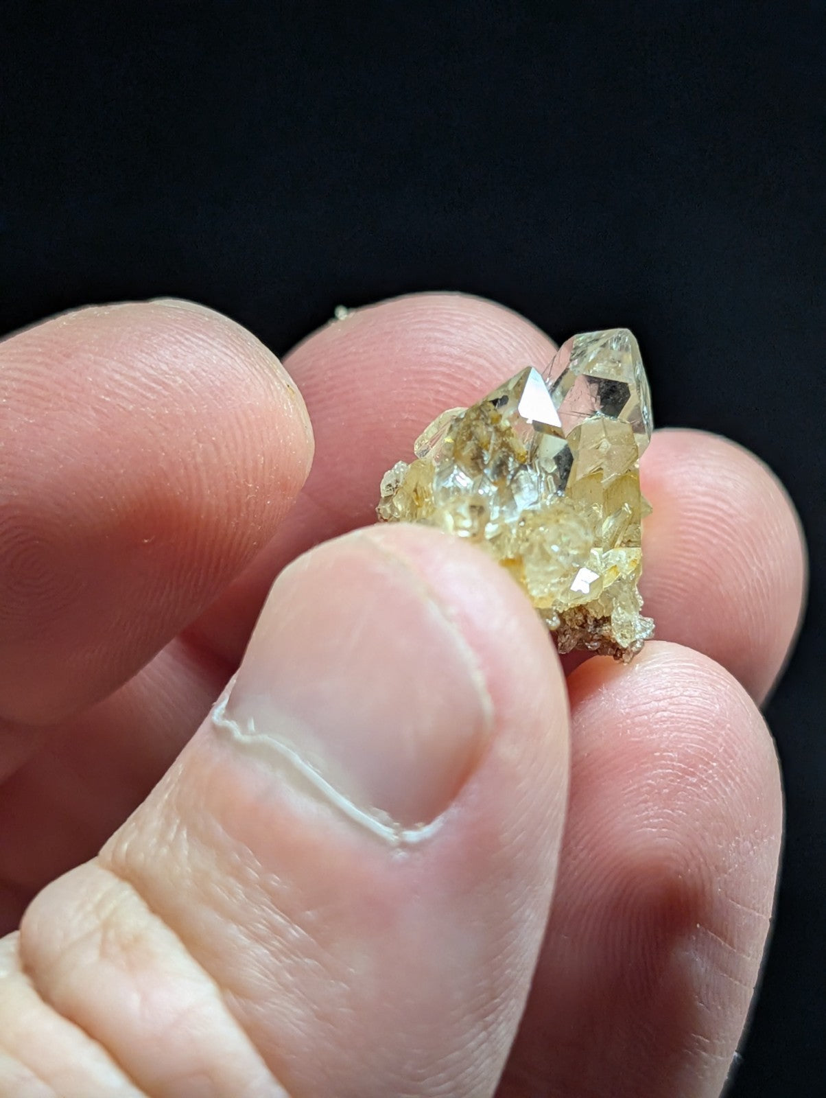 A translucent yellow crystal cluster with sharp, faceted points and a rougher base.