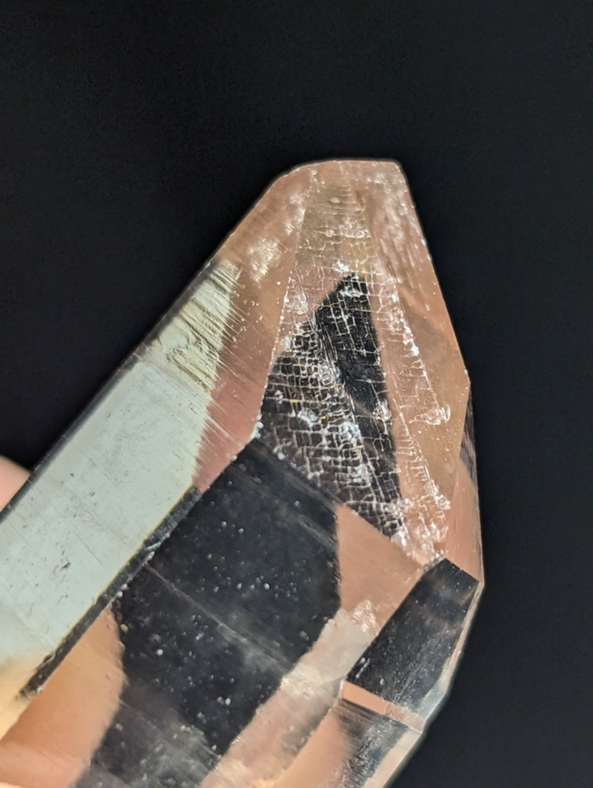 A translucent peach-colored quartz crystal with a faceted, geometric shape and visible internal inclusions.