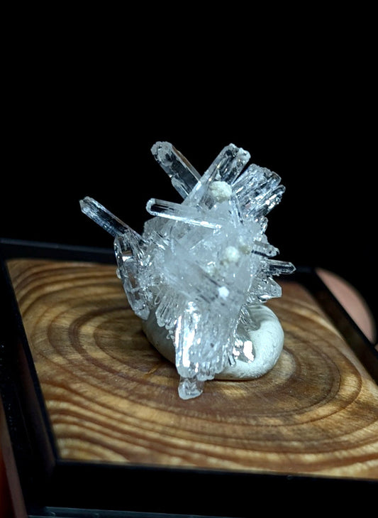 Clear quartz crystal cluster with sharp, transparent points radiating from a rounded base.