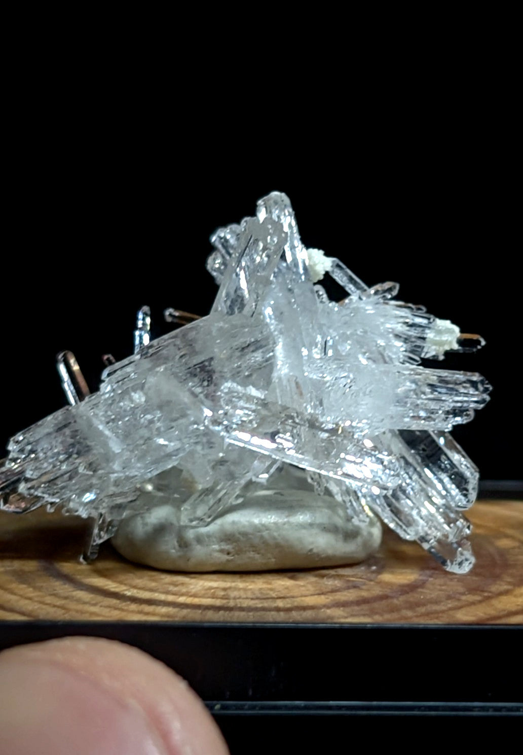 Clear, translucent quartz crystal cluster with sharp, jagged edges and a natural, earthy base.