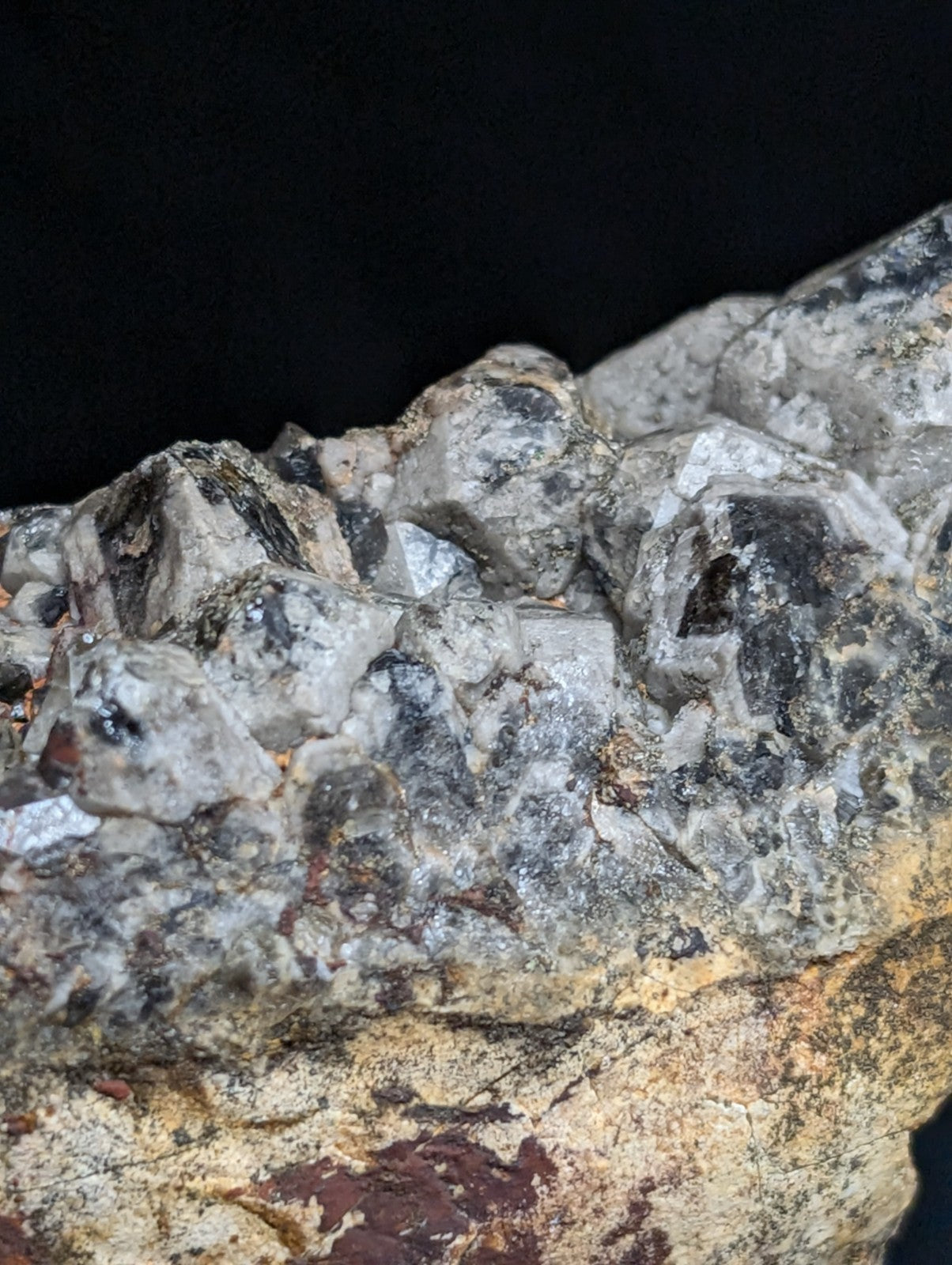 A rugged, grayish-black mineral specimen with crystalline formations and earthy matrix.