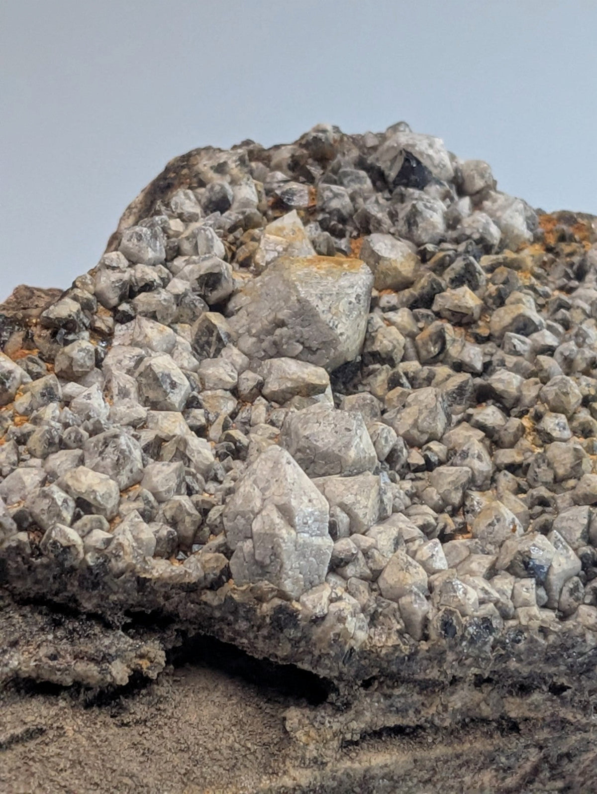 A gray, jagged rock formation with a dense cluster of crystalline minerals.