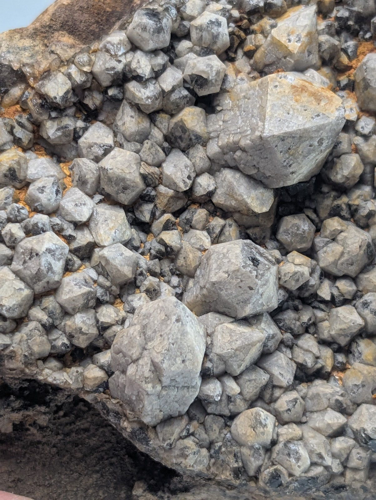 Gray crystalline rock formation with angular, faceted stones clustered together.