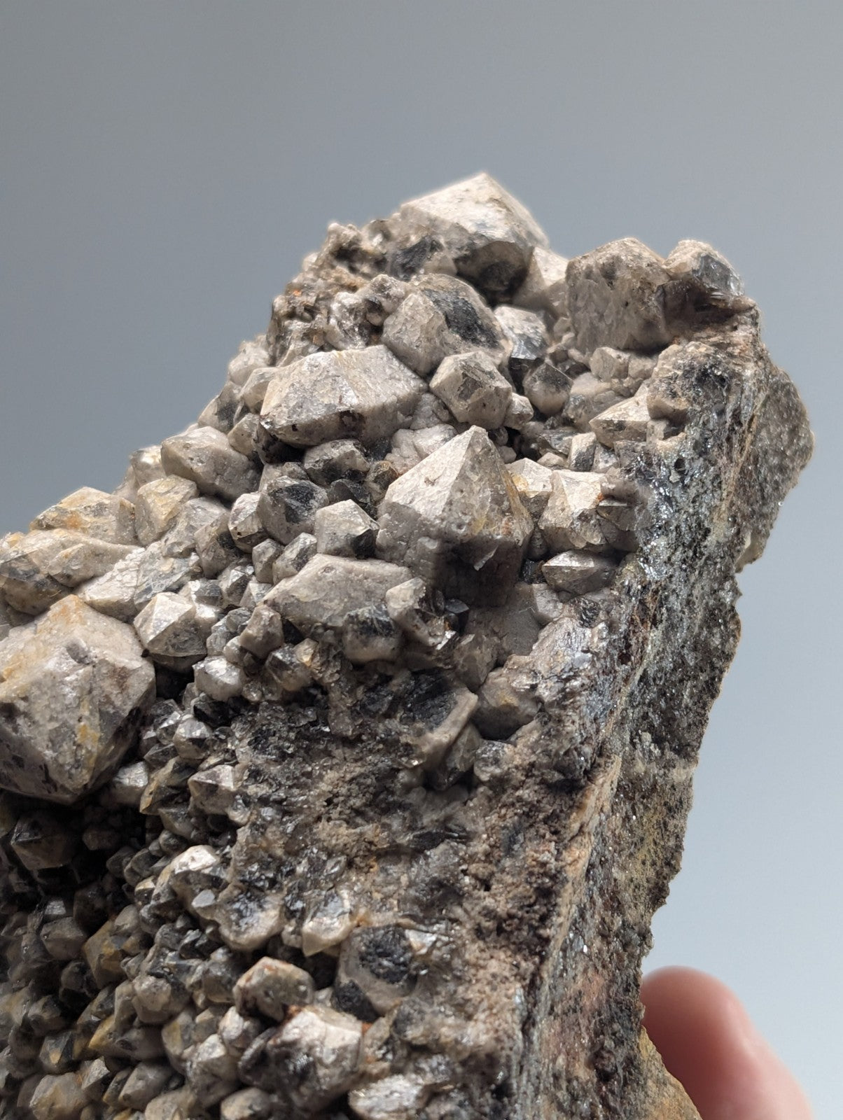 A gray, jagged mineral specimen with a rough texture and clustered crystalline formations.