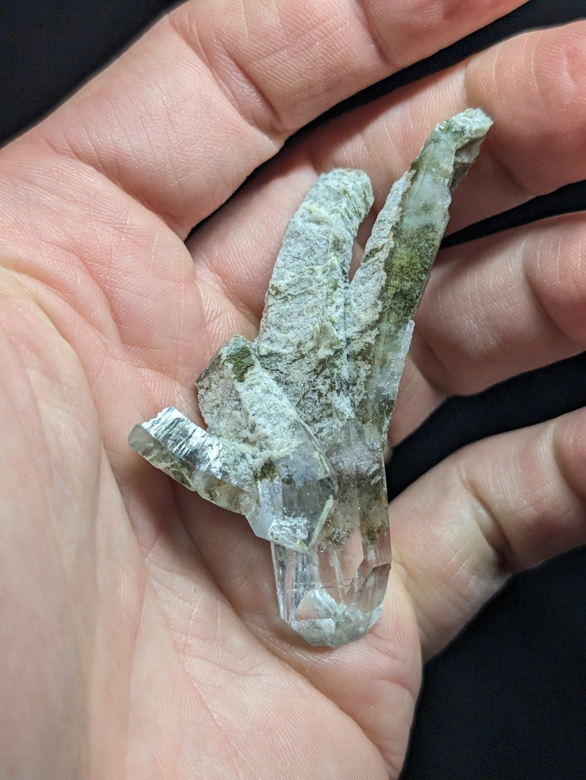 A translucent green and white quartz crystal cluster with jagged, natural facets.