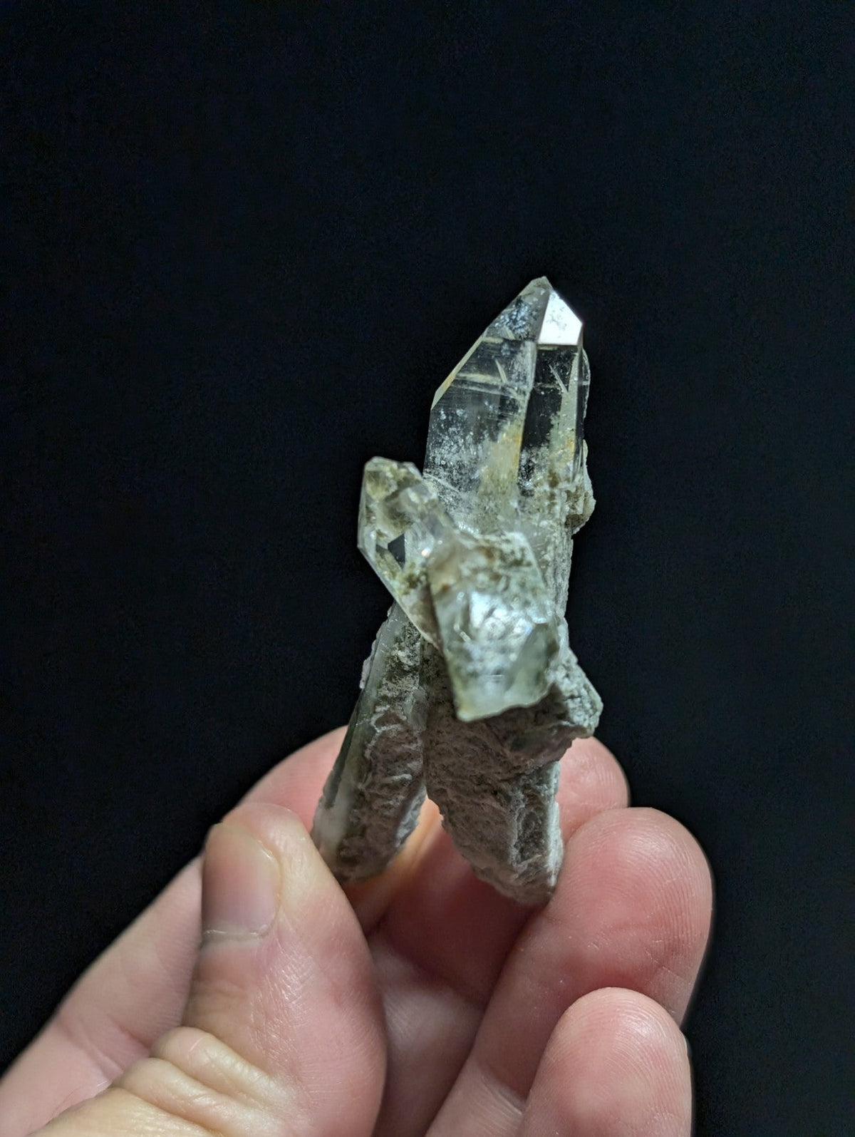A clear quartz crystal cluster with sharp, faceted points and a slightly cloudy base.