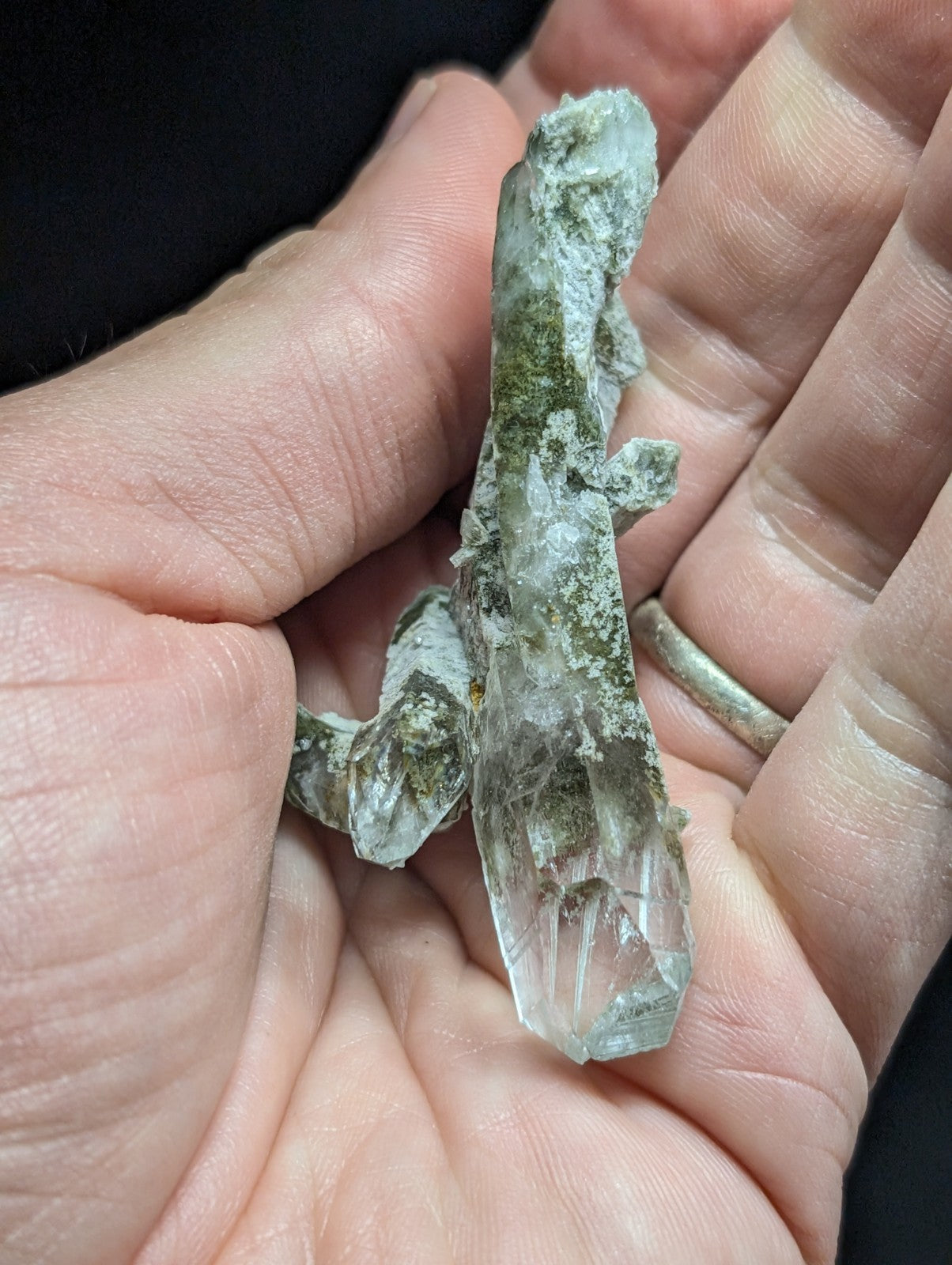 A translucent greenish-white quartz crystal cluster with a rough, mossy texture and visible internal facets.