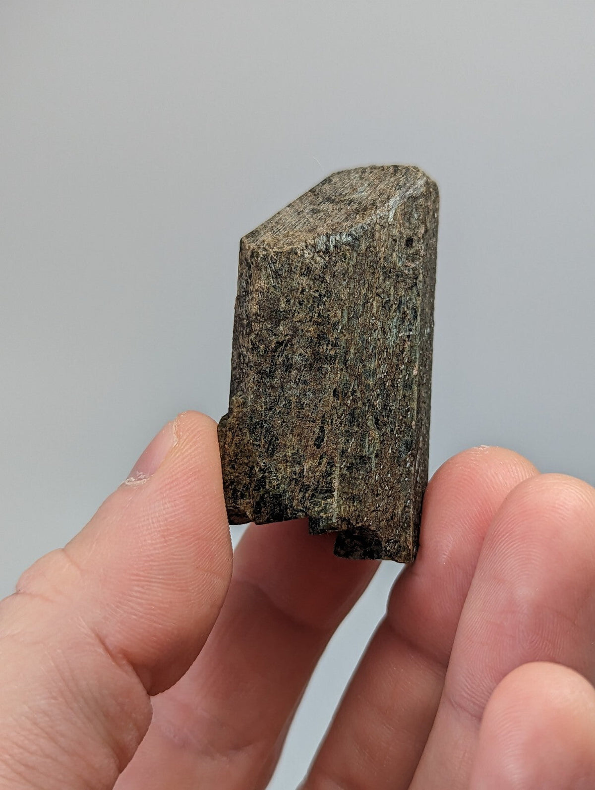A rough, dark gray stone with a textured surface and irregular edges.