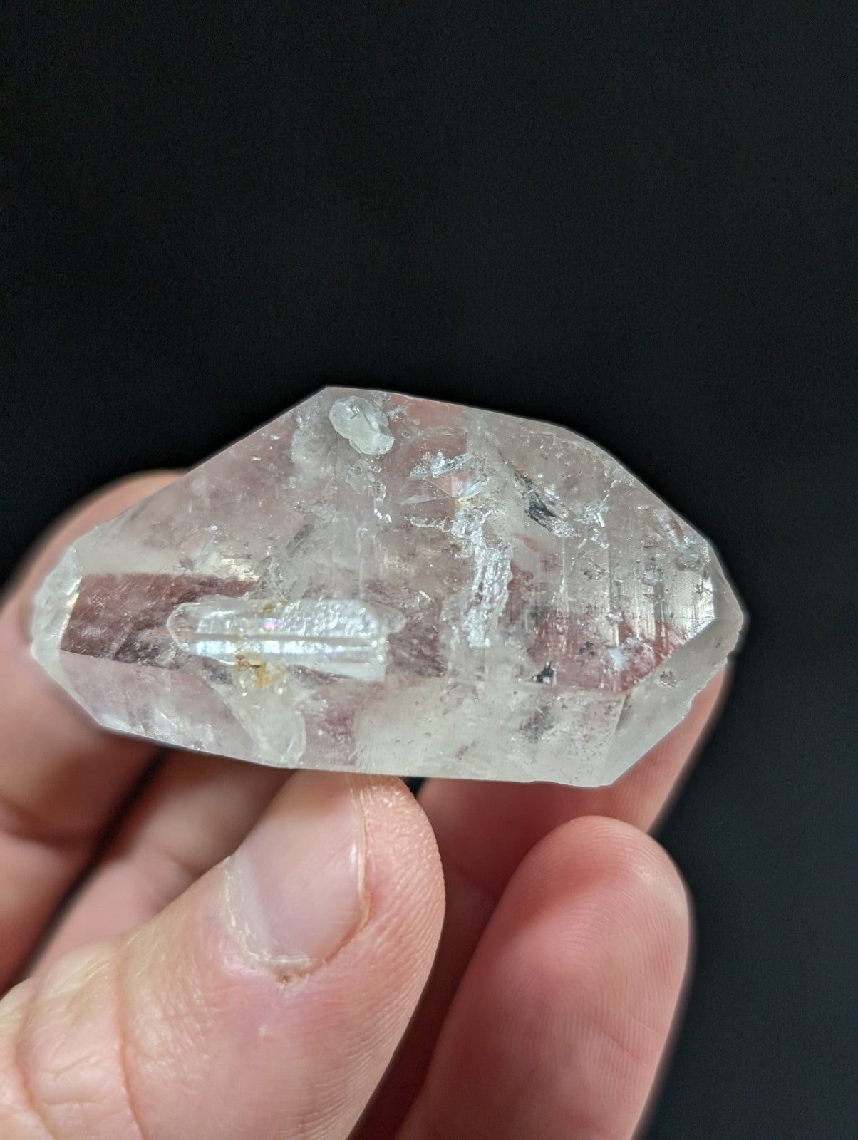 A translucent, clear quartz crystal with visible internal inclusions and a faceted surface.