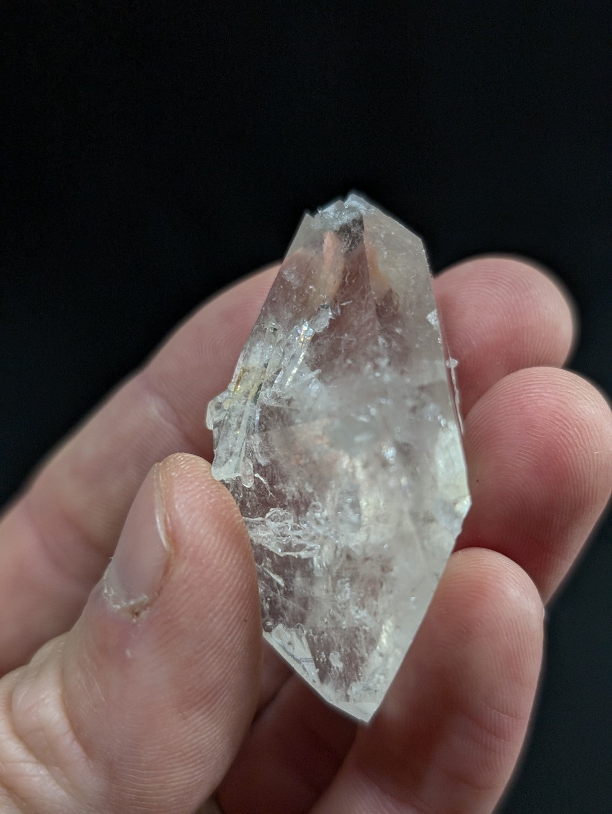 A translucent, clear quartz crystal with natural facets and internal inclusions.