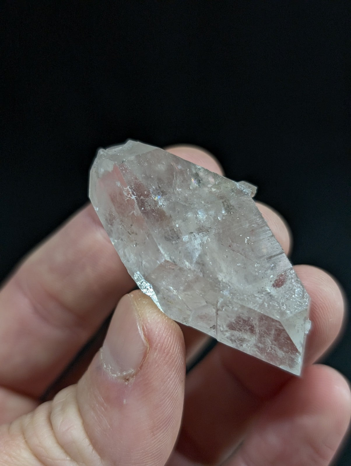 A clear, translucent quartz crystal with natural facets and internal inclusions.