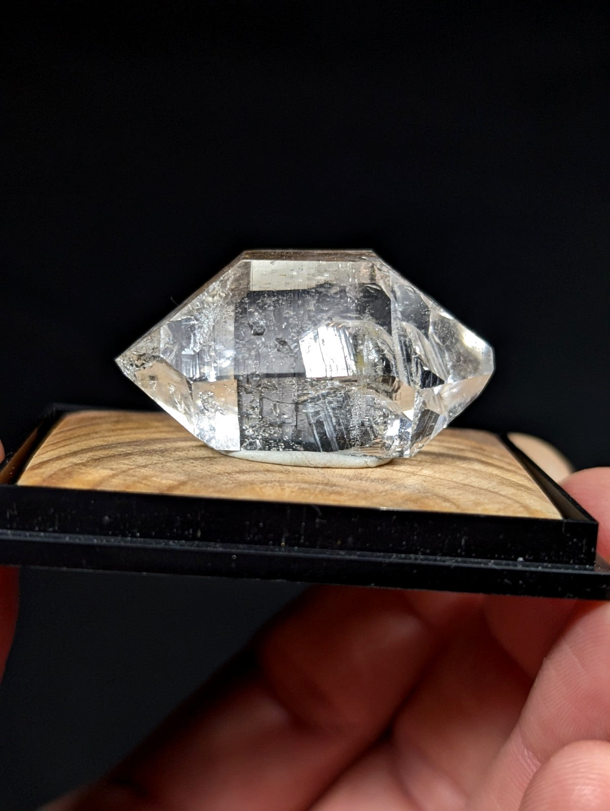 A clear, faceted quartz crystal with visible internal inclusions and a polished surface.