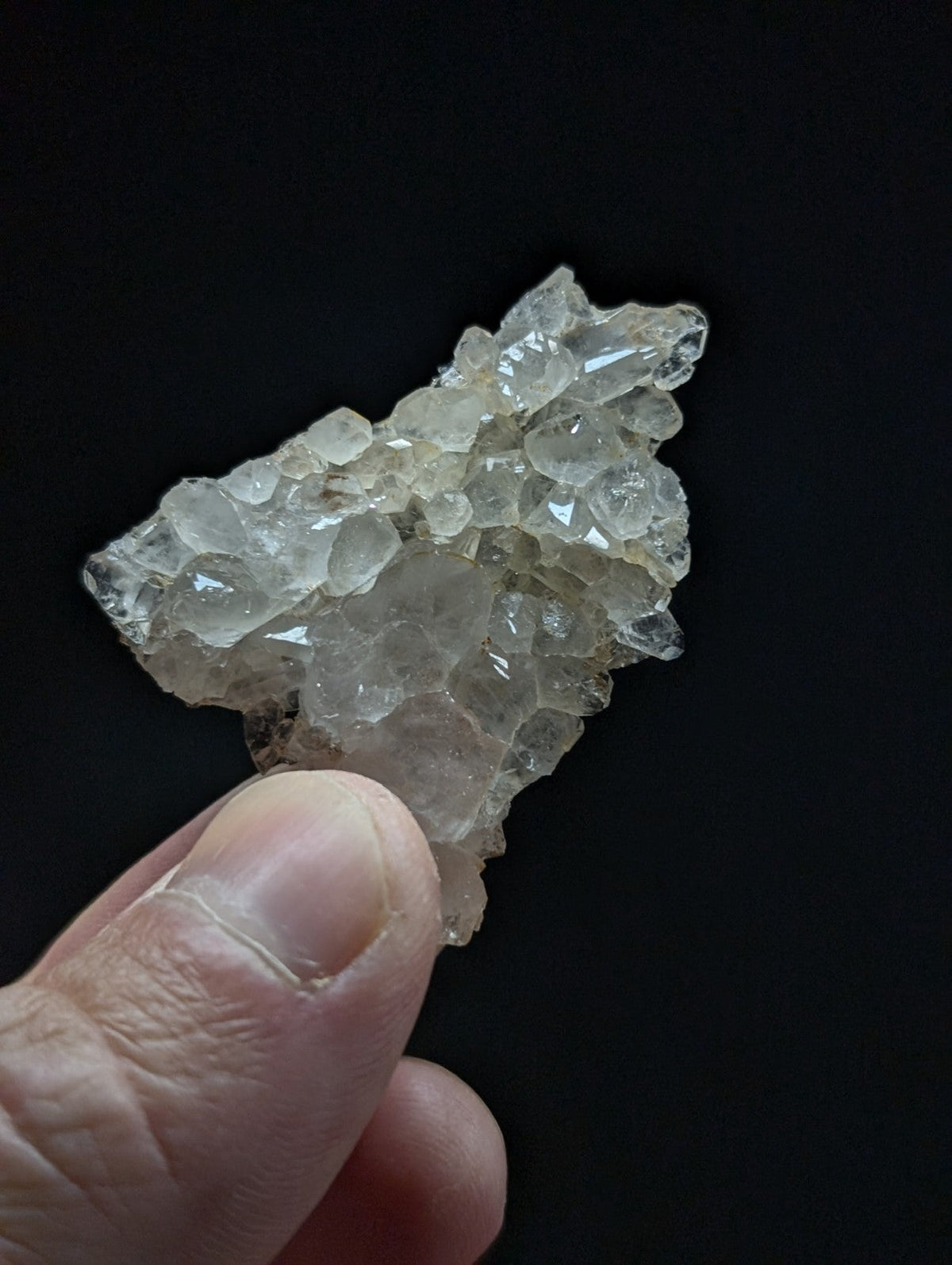 A translucent, clear quartz crystal cluster with a rough, jagged surface and multiple interlocking facets.