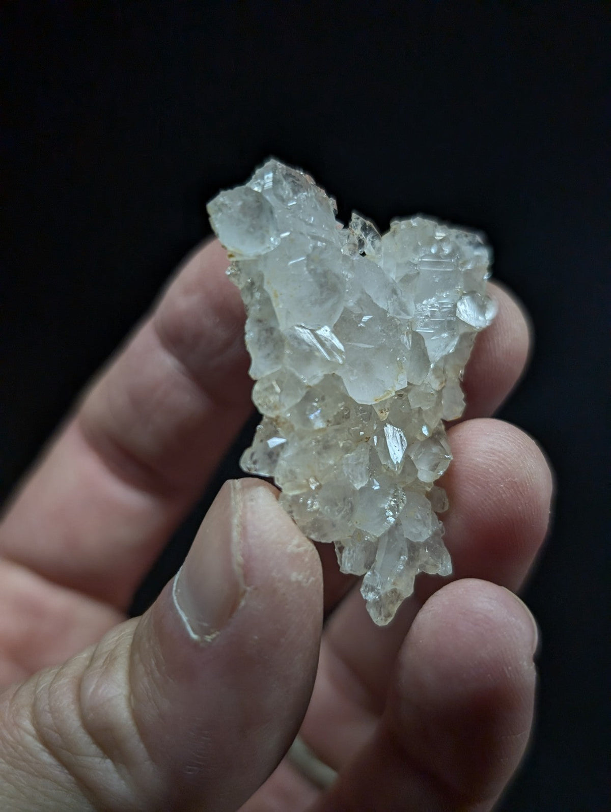 A translucent, crystalline quartz cluster with sharp facets and a pale, glassy sheen.