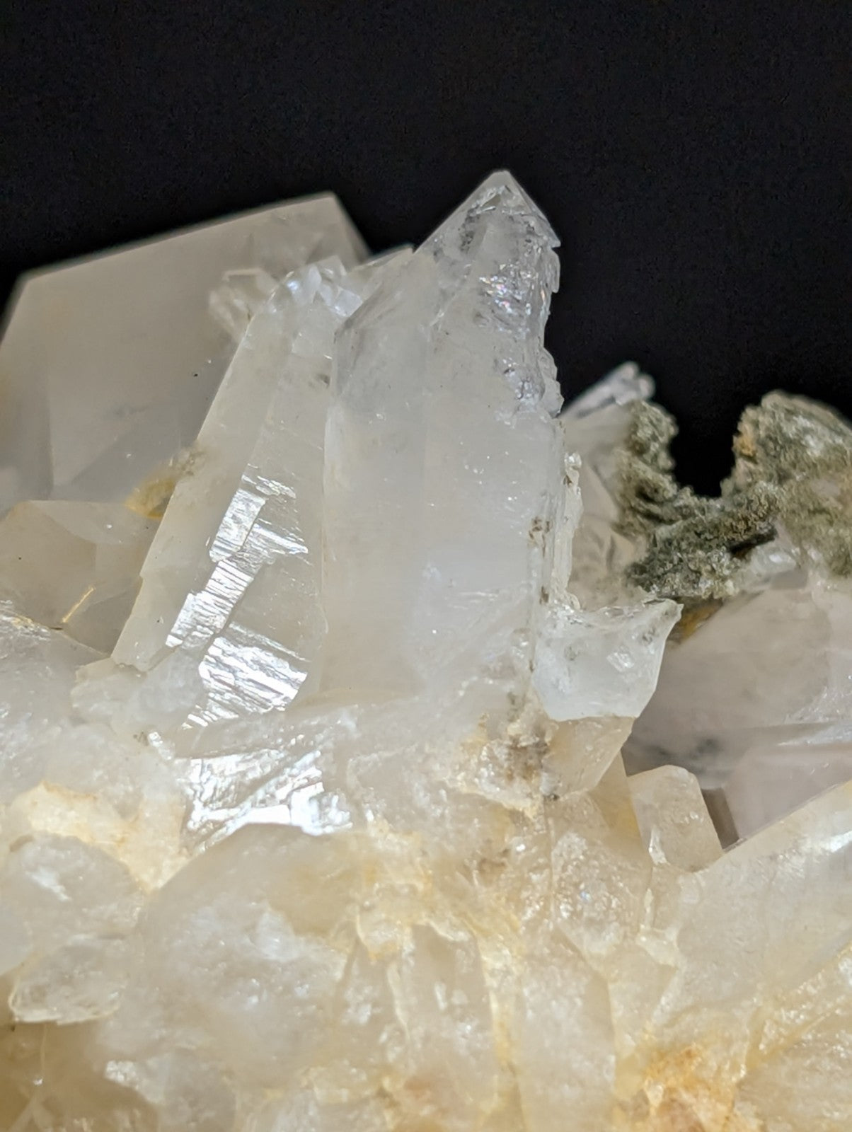 A cluster of translucent, crystalline quartz formations with sharp geometric facets and subtle internal reflections.