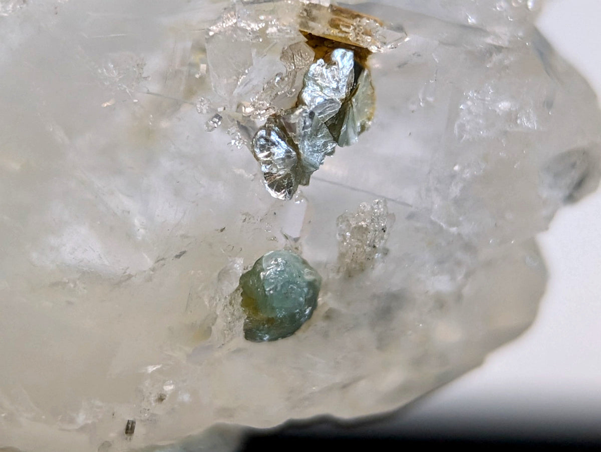 A pale green translucent faden quartz crystal with uv reactive blue green cookeite in a rough matrix from saline county arkansas