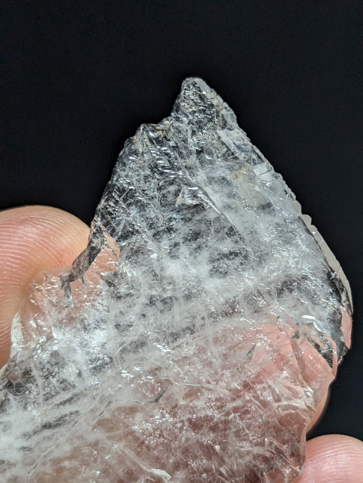 A translucent, jagged crystal with a clear and milky appearance.