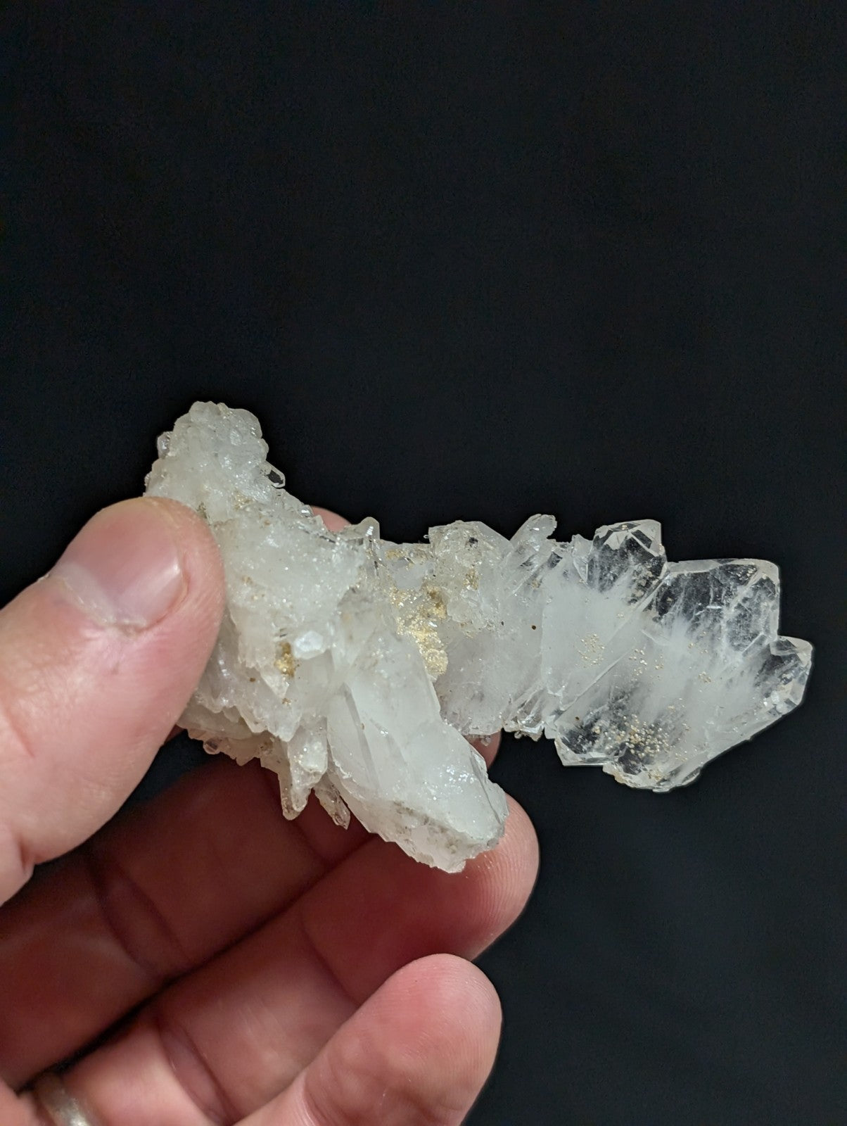 A translucent white quartz crystal cluster with delicate, interlocking facets and subtle golden inclusions.