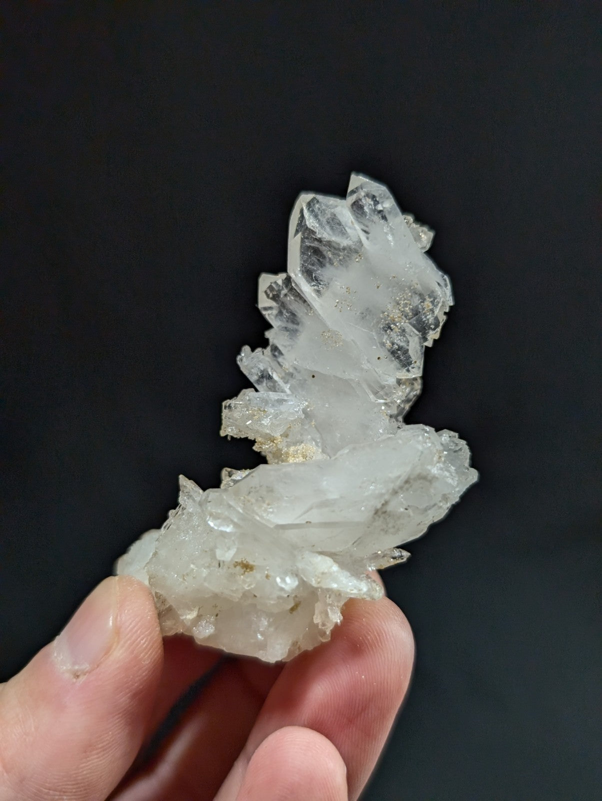 A translucent, crystalline quartz cluster with sharp, interlocking facets and subtle golden inclusions.