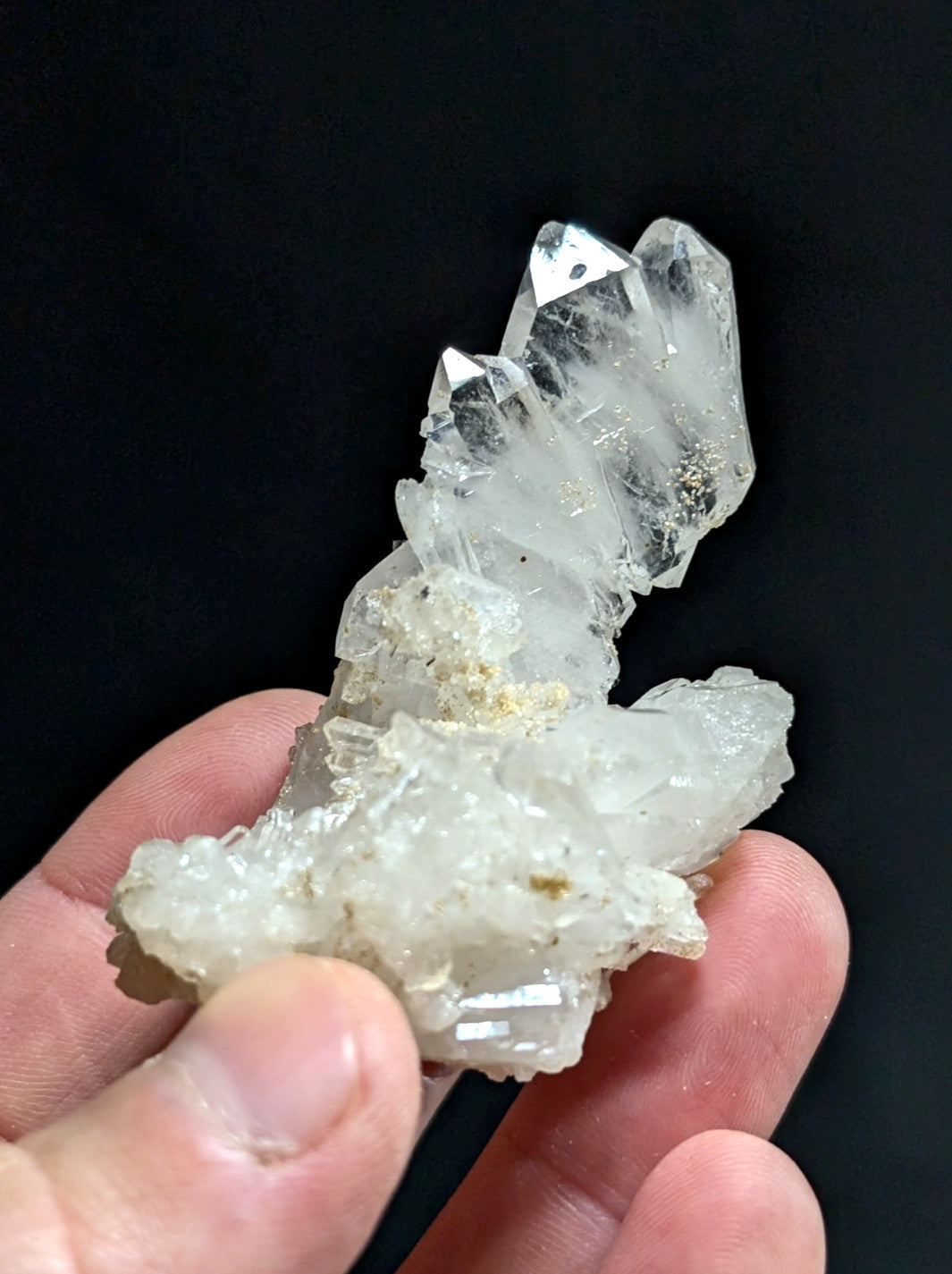 A translucent white quartz crystal cluster with sharp, faceted points and a rougher base.