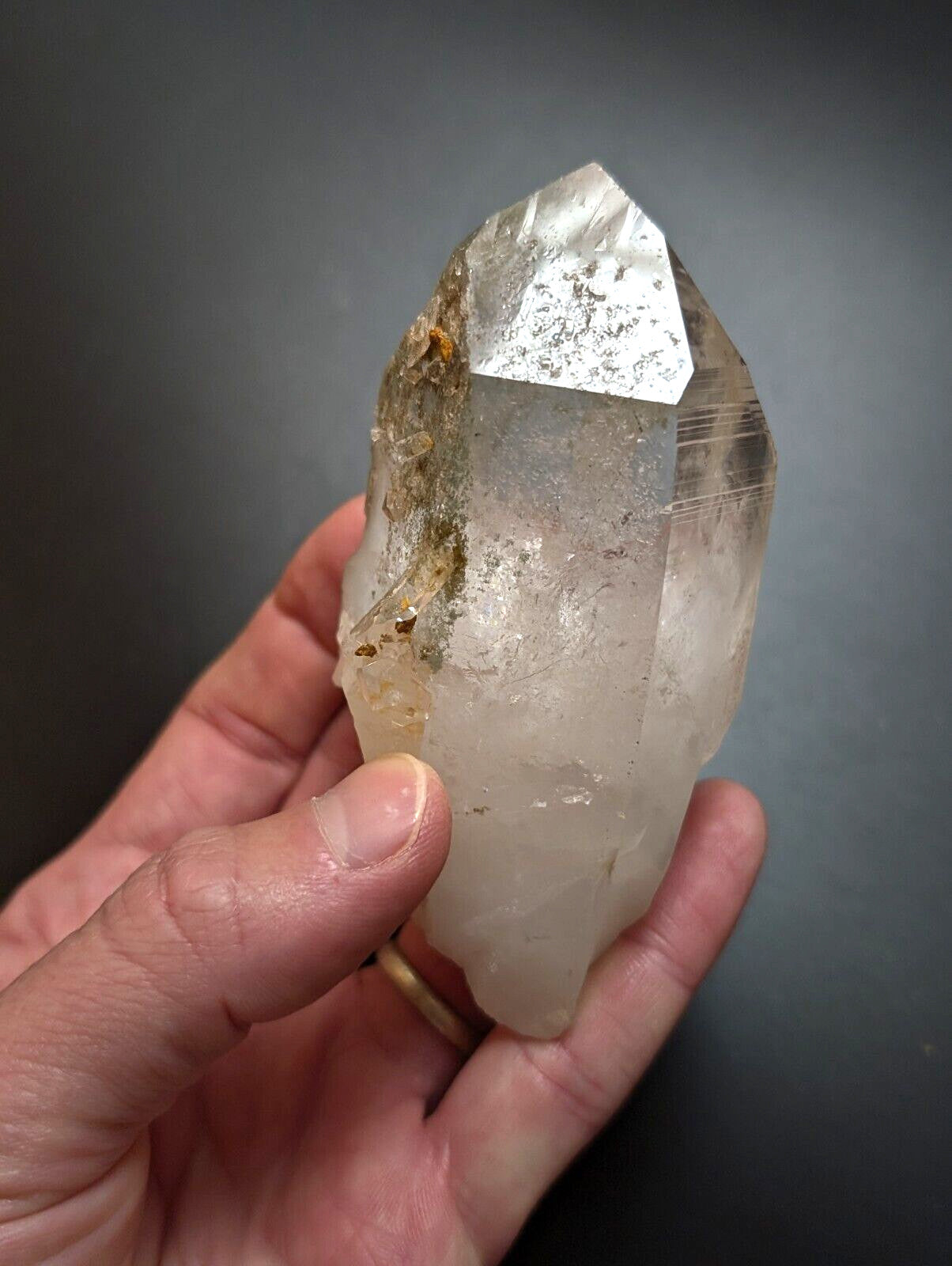 A translucent, pale quartz crystal with a pointed tip and natural inclusions.