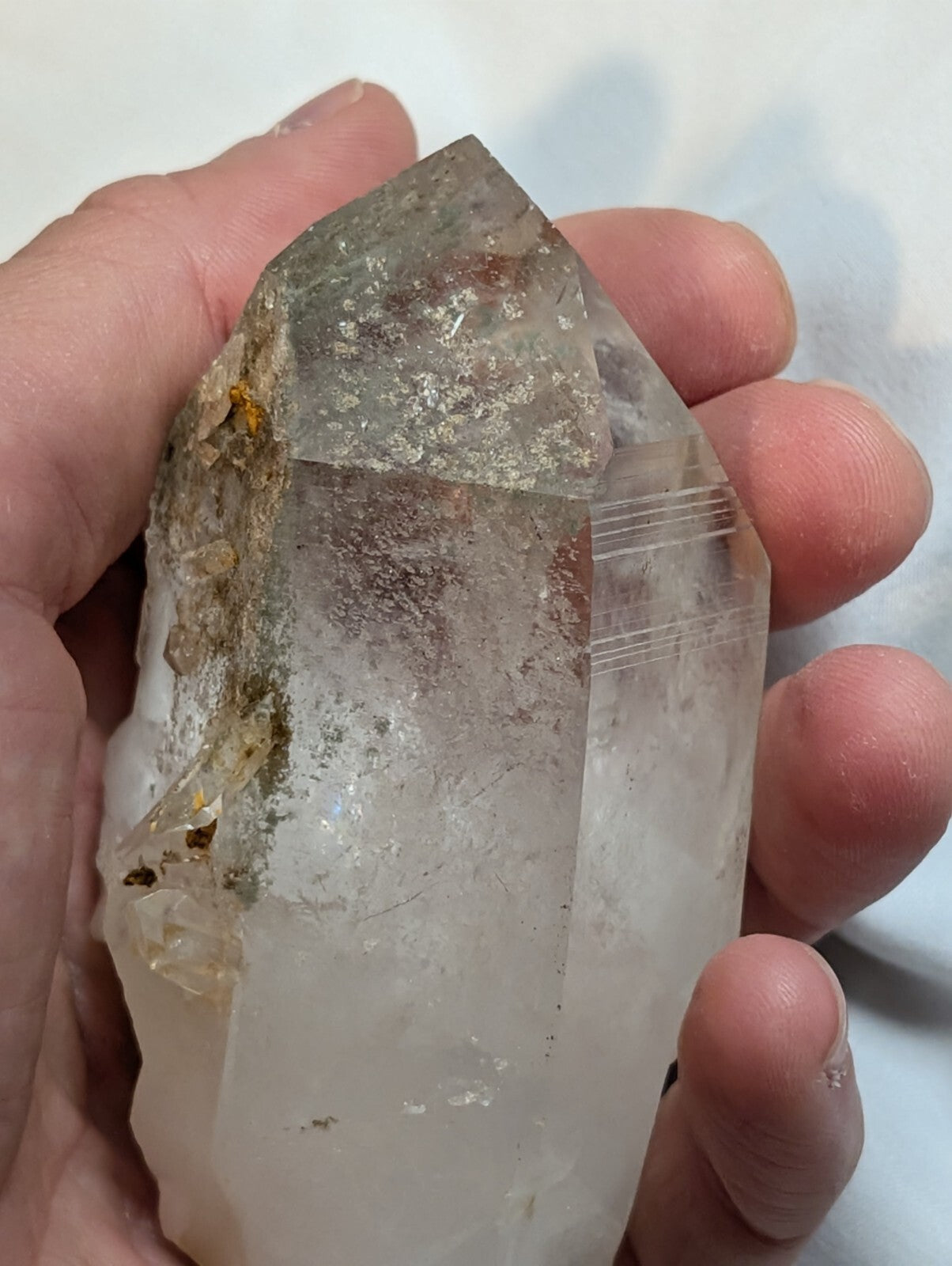 A translucent, clear quartz crystal with natural inclusions and a pointed tip.